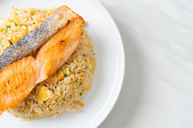 fried rice with grilled salmon fillet steak on white plate