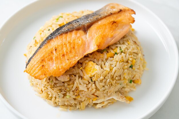 fried rice with grilled salmon fillet steak on white plate