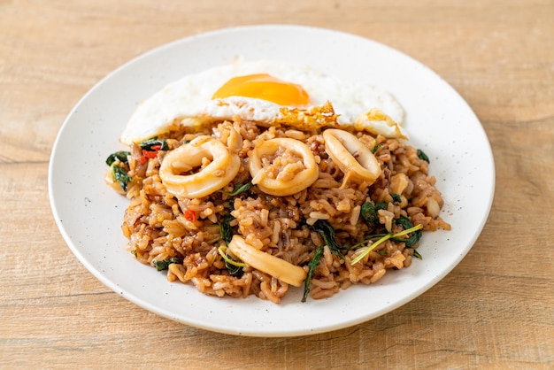 Fried rice with squid and basil topped fried egg in Thai style