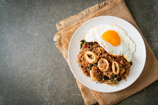 Fried rice with squid and basil topped fried egg in Thai style