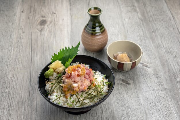 Fried rice with tuna sashimi and spawn on top over the wooden table, Luxury Japanese food concept