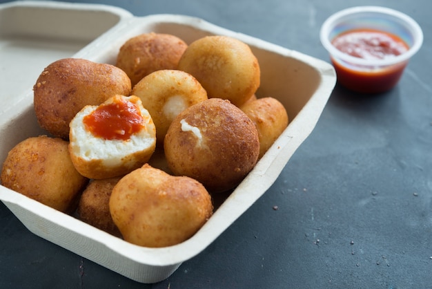 Fried Risotto Arancini stuffed with cheese, served with tomato sauce