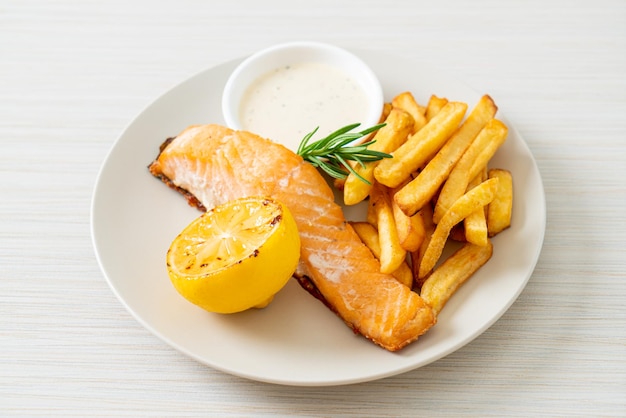 fried salmon fish and chips with lemon on plate