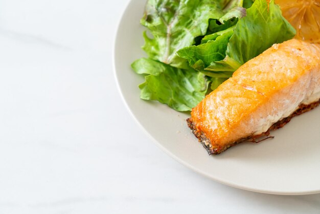 Fried salmon steak with lemon and vegetable