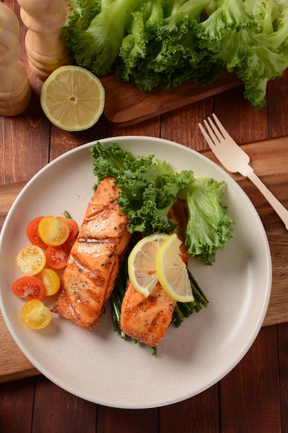 Photo fried salmon steaks cooked salmon steak with pepper herbs lemon garlic olive oil and brussels sprouts grilled fresh fish