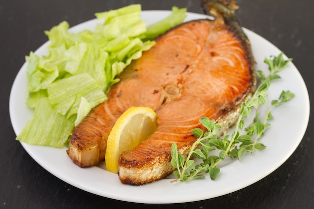 Foto salmone fritto con limone e insalata