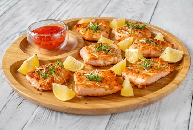 Fried salmon with sauce on the wooden serving tray