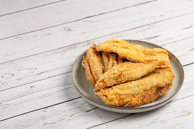 Fried sardines in the plate on the table.