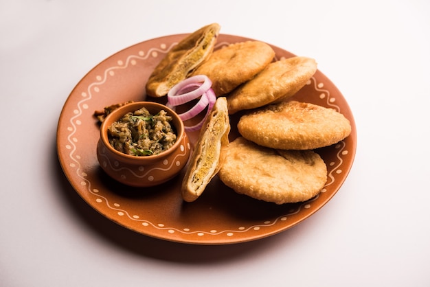 Photo fried sattu litti chokha served with baingan bharta, onion and pickle, popular recipe from bihar, india