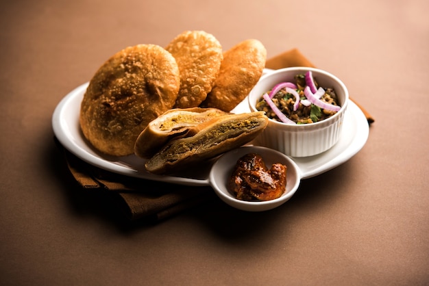 Photo fried sattu litti chokha served with baingan bharta, onion and pickle, popular recipe from bihar, india