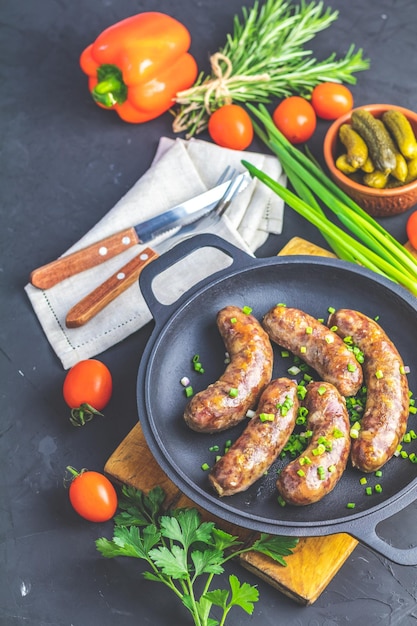 Photo fried sausage in a frying pan with herbs and spices