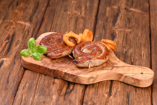 Fried sausage on kitchen wooden cutting board