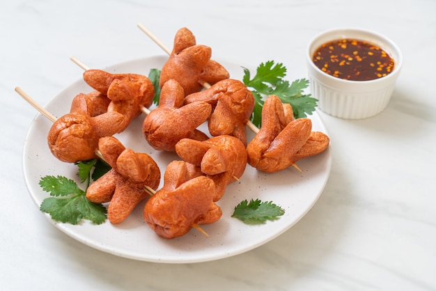 fried sausage skewer with dipping sauce
