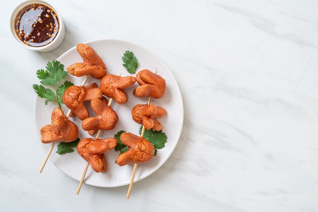 fried sausage skewer with dipping sauce