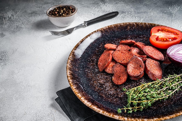 Fried sausage sucuk from beef meat on a plate with herbs White background Top view Copy space