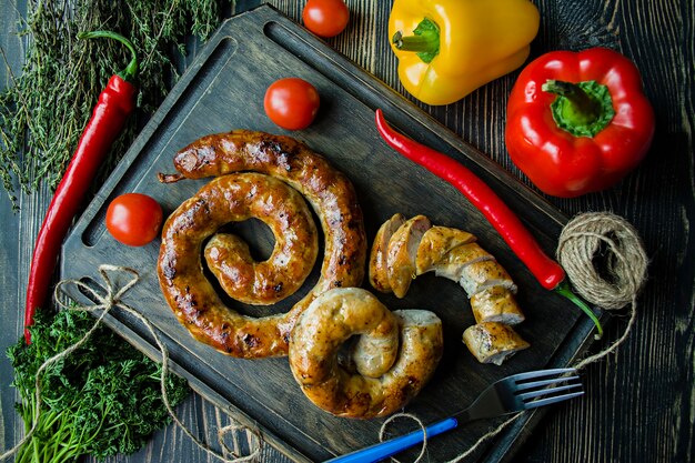 Salsiccia fritta con erbe e spezie, in legno.