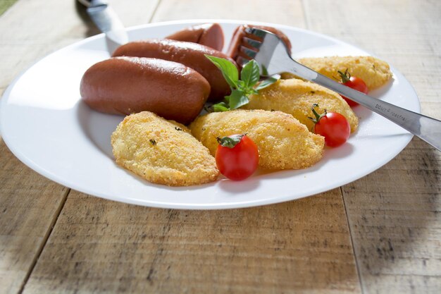 Foto salsicce fritte e patate al pane