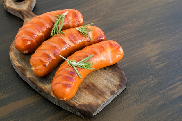 Fried sausages on a cast iron pan. on the board