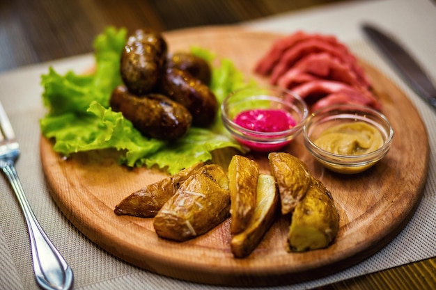 Fried sausages with potatoes and mustard sauces in restaurant