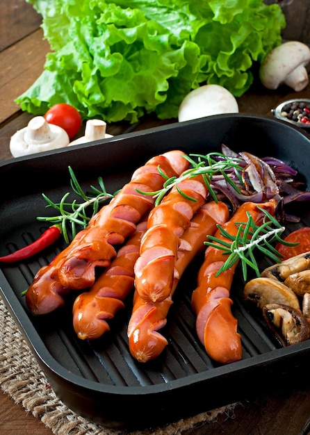 Fried sausages with vegetables on a white plate