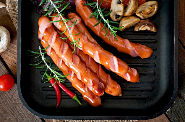 Fried sausages with vegetables on a white plate