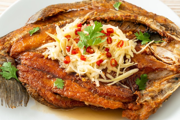 Жареный морской окунь с рыбным соусом и острым салатом
