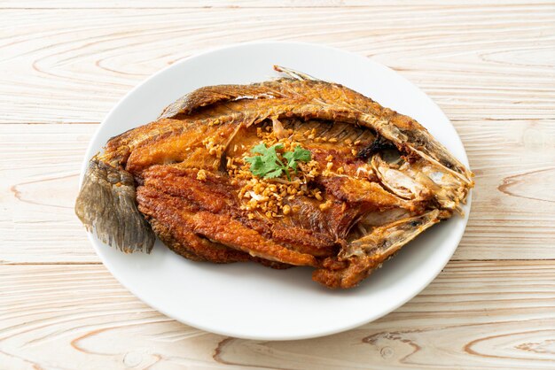 Fried Sea Bass Fish with Garlic on plate