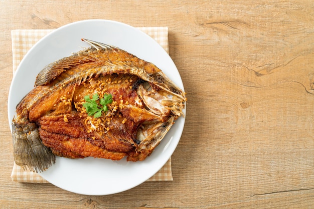 Fried Sea Bass Fish with Garlic on plate