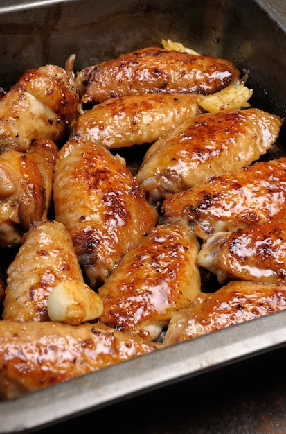 Fried sharply spicy chicken wings on a baking closeup