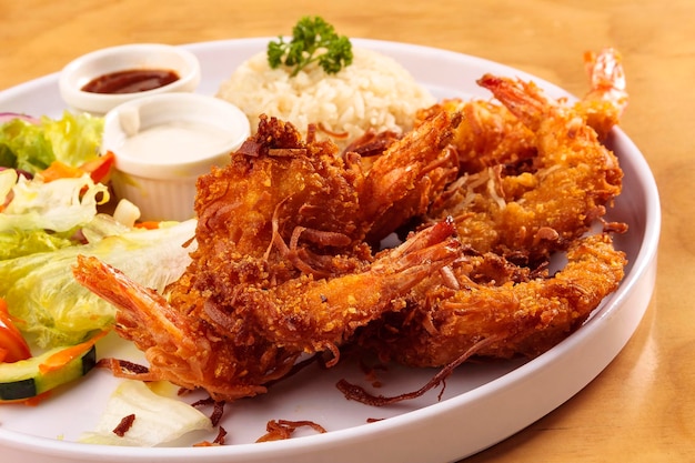 Fried shrimp breaded with coconut, sweet sauce, salad and rice, food, gastronomy