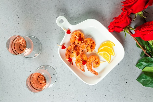 Gamberi fritti, rose e champagne. antipasto originale per san valentino, cena romantica