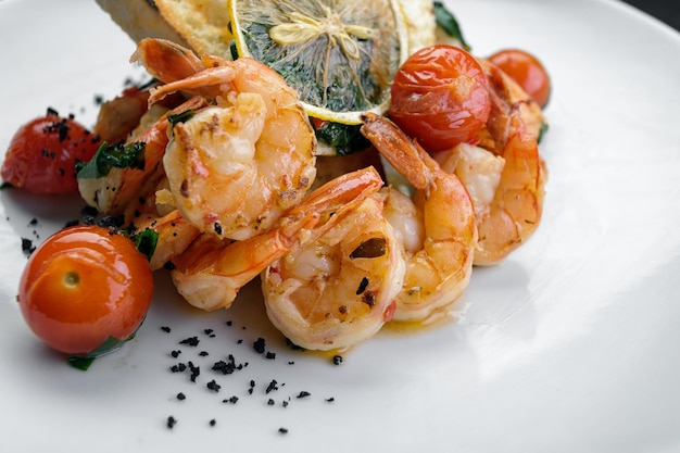 Fried shrimp in tomato sauce with lemon and tomatoes