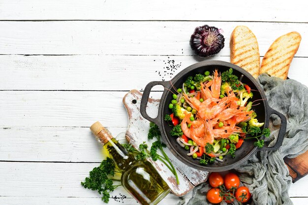 Fried shrimp with vegetables in a frying pan Seafood Top view Free space for your text