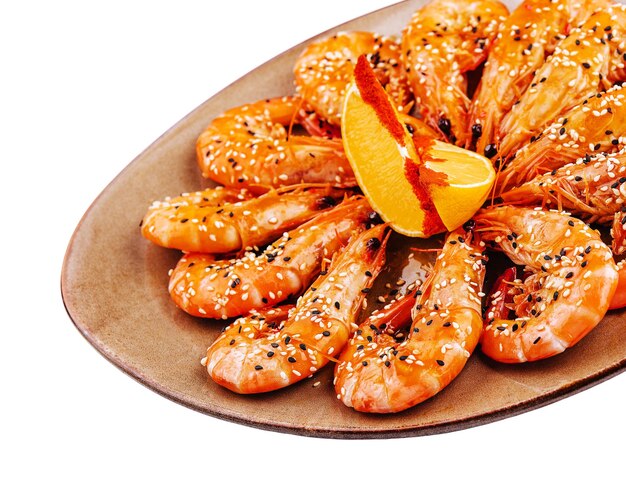 Fried shrimps on a plate with sesame and two slices of lemon