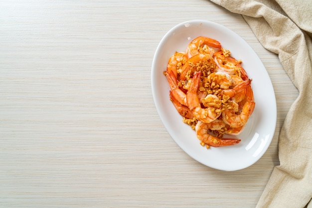 жареные креветки или креветки с чесноком на белой тарелке - морепродукты