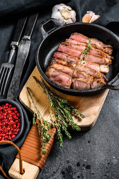 Fried sliced marble pork steak in a pan.