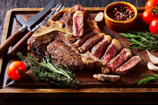 Photo fried sliced porterhouse steak on a wooden board