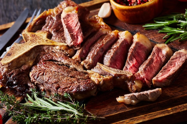 Fried sliced porterhouse steak on a wooden board