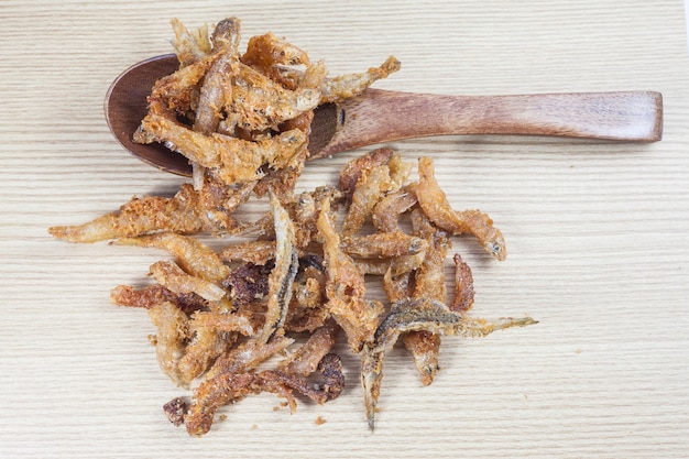 Fried small fish on wood background