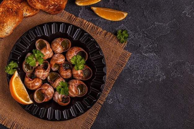 Fried snails with lemon, baguette and parsley