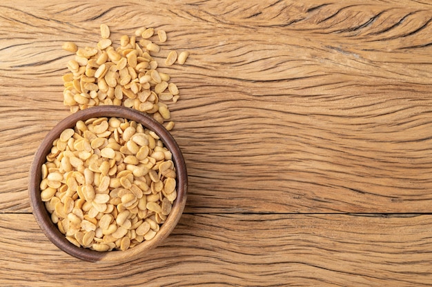 Fried soy beans snack in a bowl over wooden table with copy space