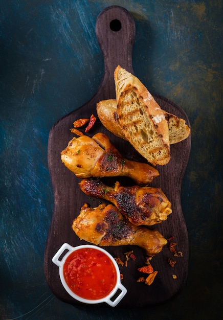 Foto cosce di pollo piccanti fritte sul legno con la salsa