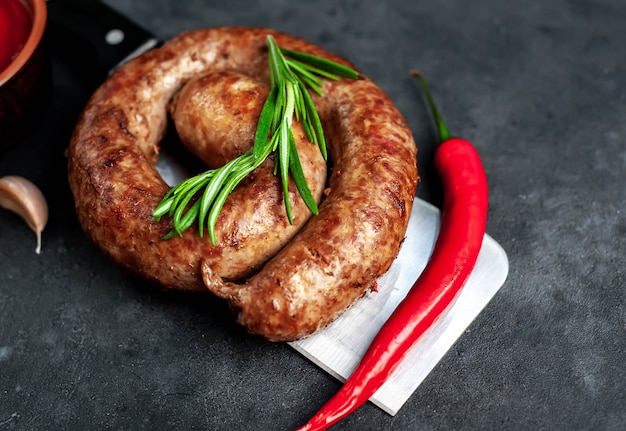 Fried spiral sausage with spices on a meat knife