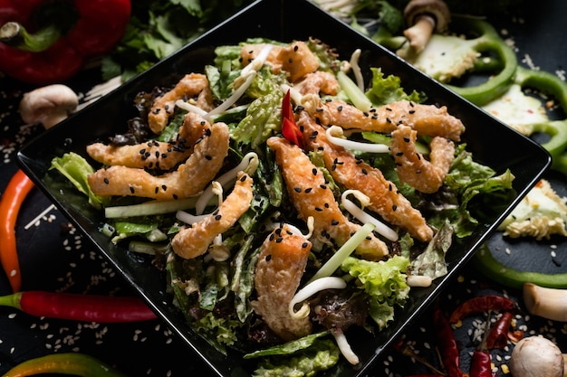 Fried squid wheat sprouts and vegetable salad in a bowl