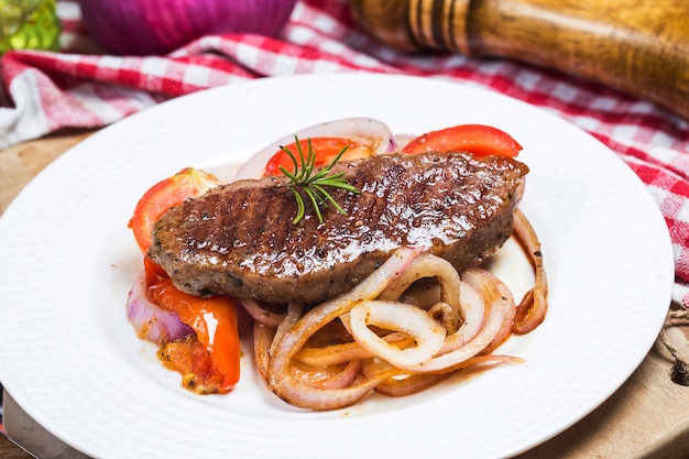 Foto bistecca fritta, pomodoro, cipolla