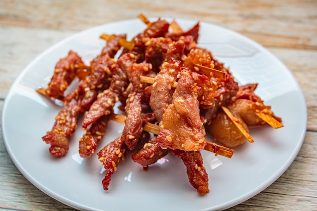 Alimento tailandese di stile seccato al sole fritto della carne di maiale.