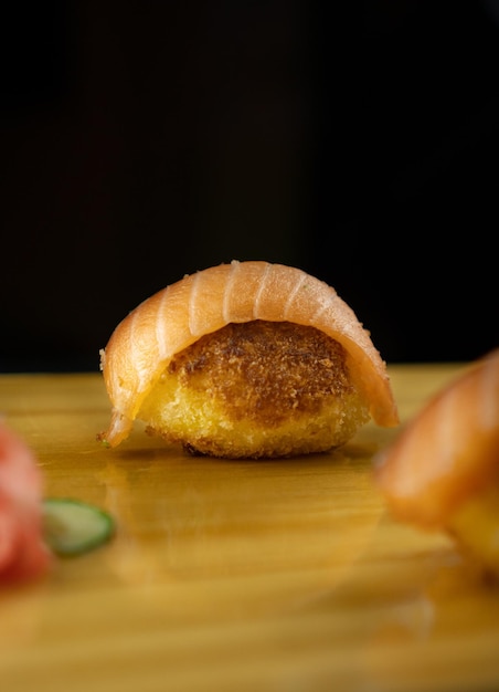 Foto sushi fritto con salmone grande pezzo di sushi con salmone rosa
