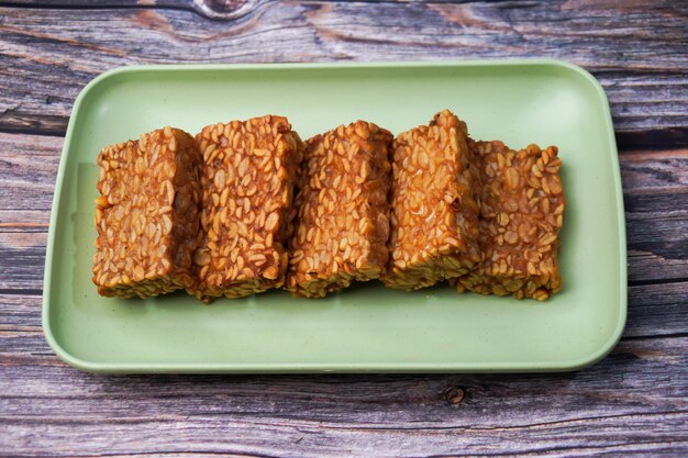 Foto tempeh fritto in un contenitore su un tavolo di legno