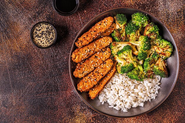 Fried tempeh with rice and broccoli, traditional indonesian cuisine.