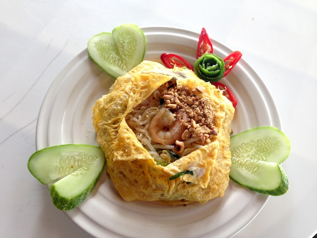 Fried Thai noodle with shrimp wrapped in egg.